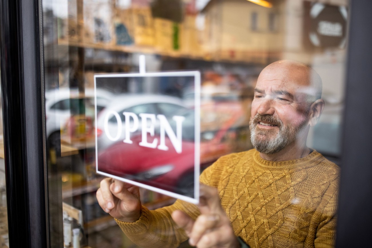 Man in storefront with open sign